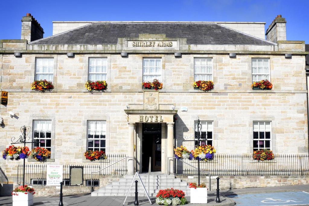 un edificio de piedra con flores delante en The Shirley Arms Hotel, en Carrickmacross