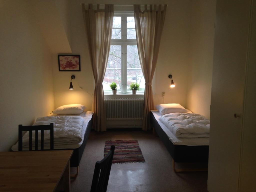 um quarto com duas camas e uma janela em Ronneby Brunnspark Vandrarhem och B&B em Ronneby