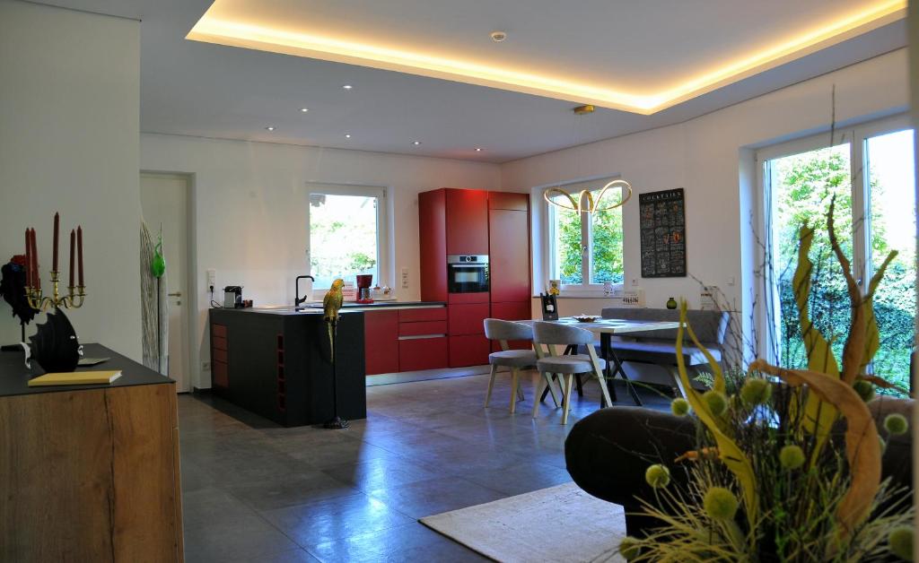cocina y comedor con armarios rojos y mesa en Ruhige Ferienwohnung mit Garten und Garage in Privatvilla, en Marlengo