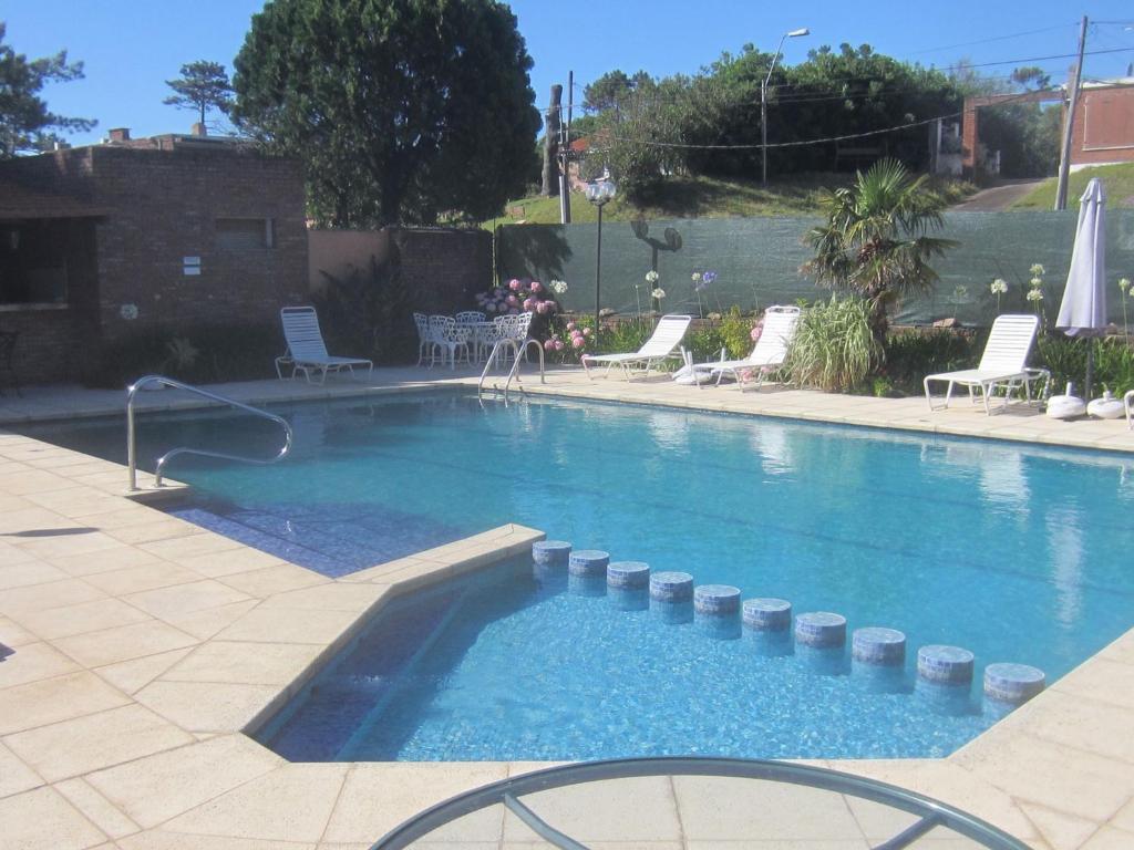 a large swimming pool with chairs and a table at Brisas del Este in Punta del Este