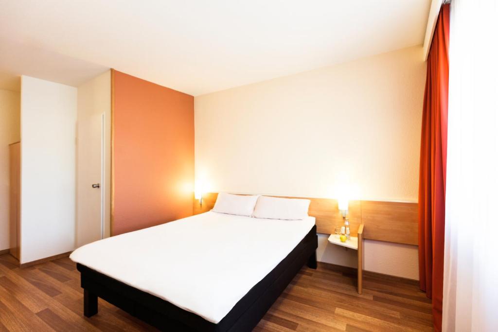 a bedroom with a bed and a desk at Ibis Graz in Graz