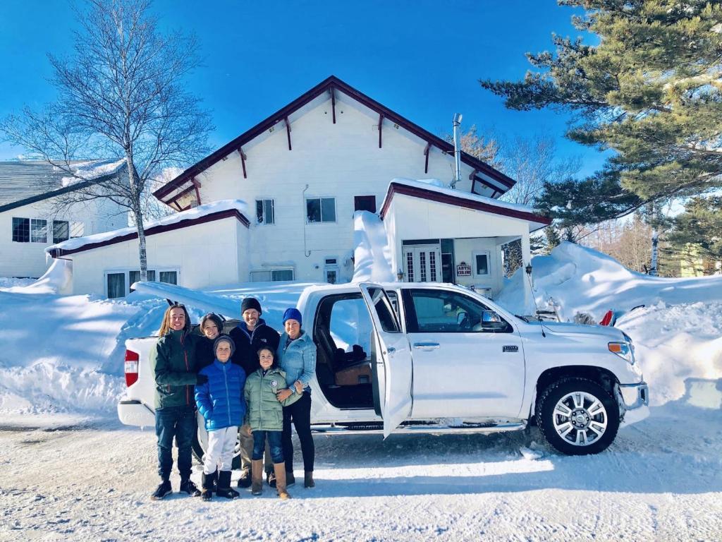 een familie poseert voor een truck in de sneeuw bij Appi Arts Color in Hachimantai