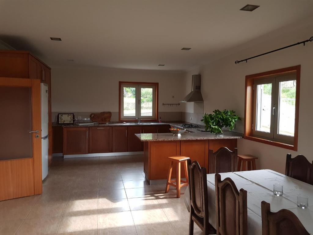 a kitchen with wooden cabinets and a table and chairs at Casa da Oliveira in Mondim de Basto