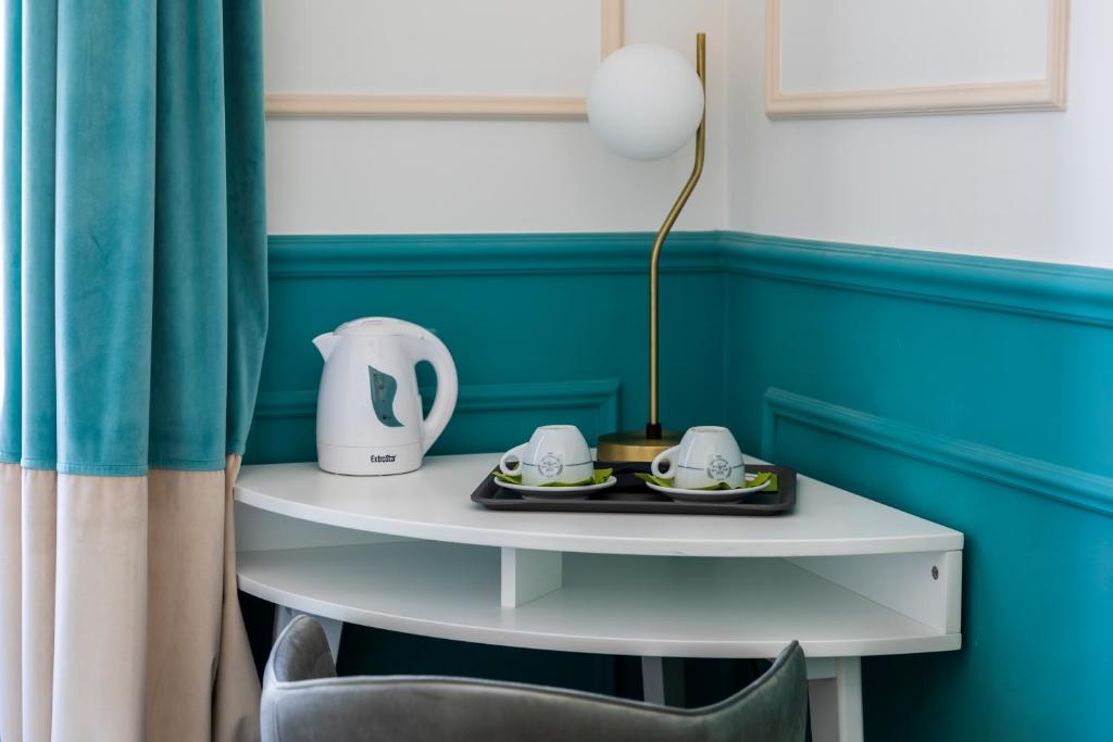 a table with a lamp and two teaisers on it at Hotel Coppede' in Rome