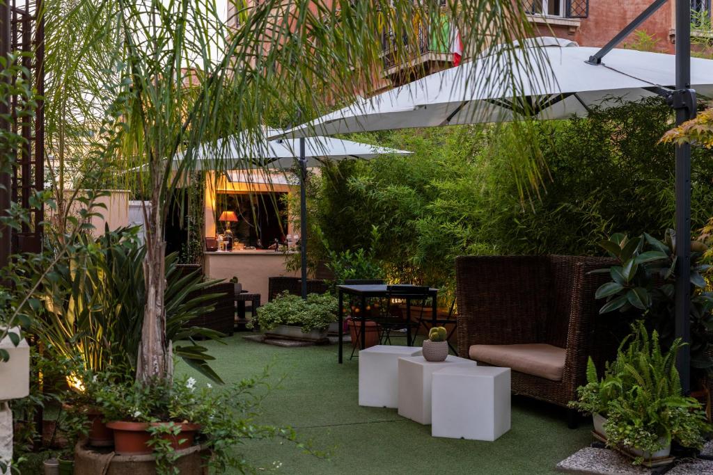 einen Garten mit einem Stuhl und einem Sonnenschirm in der Unterkunft Hotel Coppede' in Rom