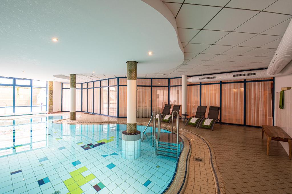 a swimming pool in a large building with a pool at Heide Hotel Reinstorf in Reinstorf