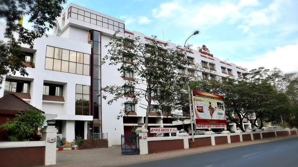 un edificio blanco al lado de una calle en Breeze Residency, en Tiruchchirāppalli