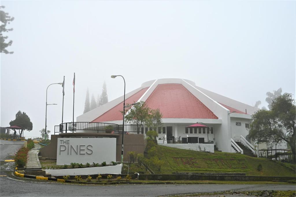 um grande edifício branco com uma placa em frente em The Pines at Fraser's Hill, Malaysia em Bukit Fraser