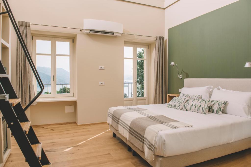 a bedroom with a bed and a staircase with windows at Casa Rampolina in Stresa