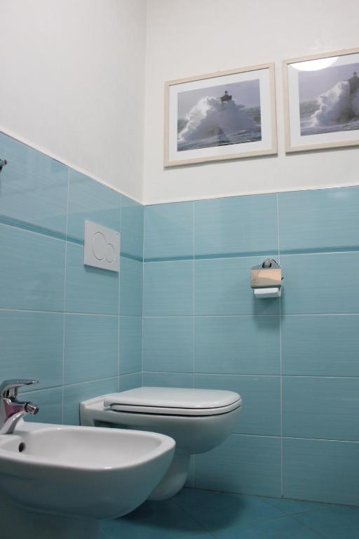 a blue bathroom with a toilet and a sink at Coco'S Rooms in Bari Palese
