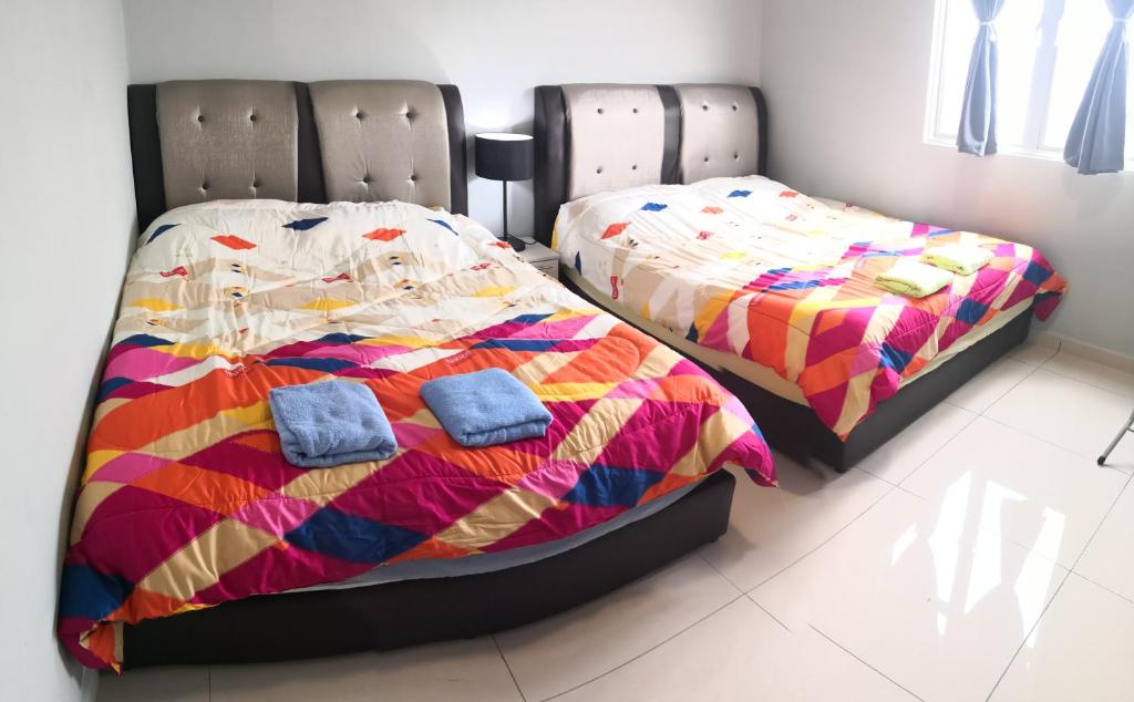 two beds sitting next to each other in a bedroom at Mcz homestay ipoh town 2room 7pax free wifi in Ipoh