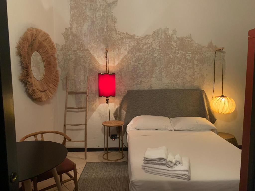 een slaapkamer met een bed en een rode lamp bij Mood-Garibaldi in Pavia