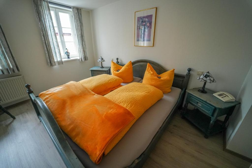 uma cama com almofadas cor de laranja num quarto em Hotel Celler Auszeit em Celle