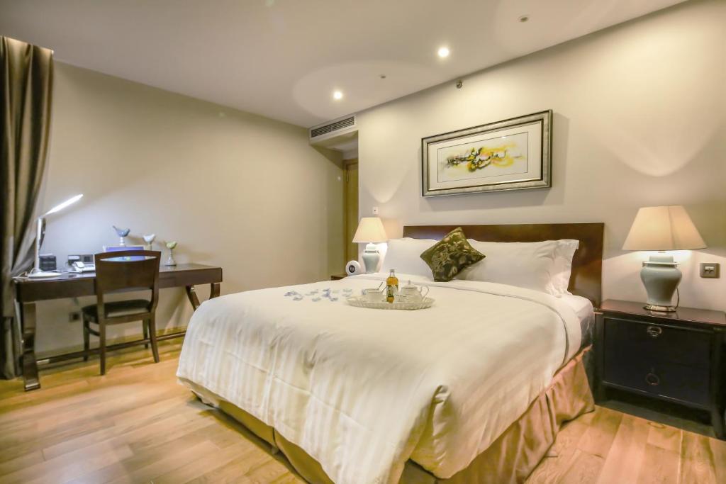 a hotel room with a large bed and a desk at Green Court Residence Jinqiao Diamond Shanghai in Shanghai