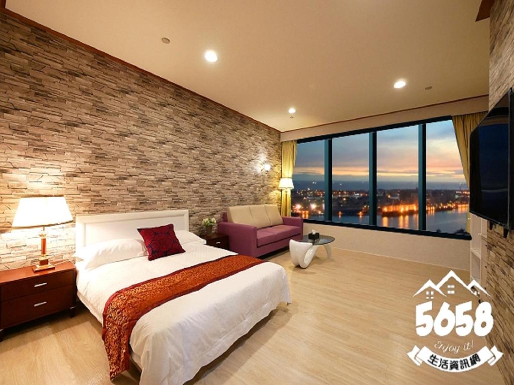 um quarto com uma cama grande e uma parede de tijolos em 85 Season em Kaohsiung