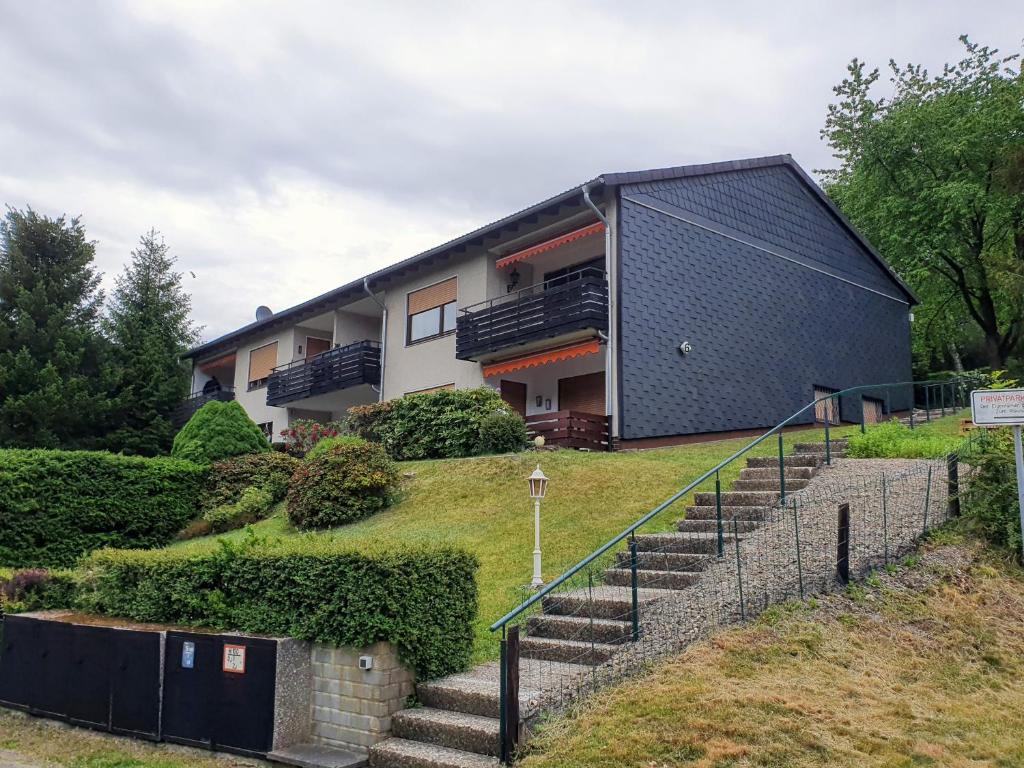 a house on a hill with stairs in front of it at Schöne Ferienwohnung in Lautenthal im Harz in Lautenthal