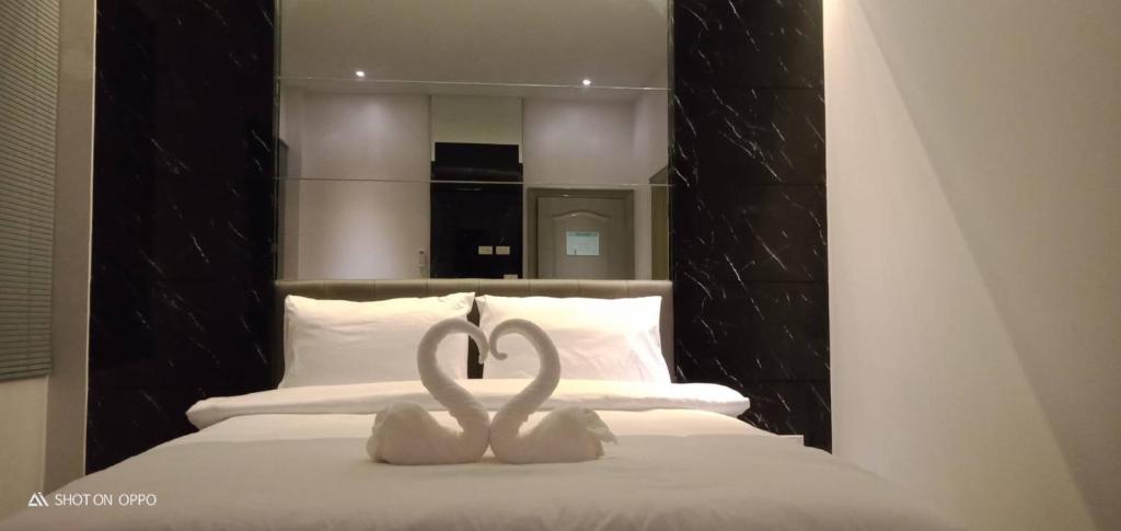 a couple of white hearts on top of a bed at Chics Resort ชิคส์รีสอร์ท in Ban Khlong Nung