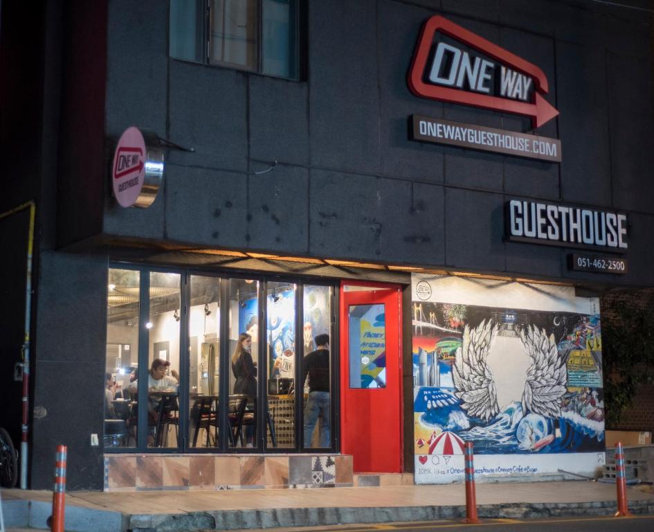 un magasin devant un restaurant avec une porte rouge dans l'établissement One Way Guesthouse Busan, à Busan