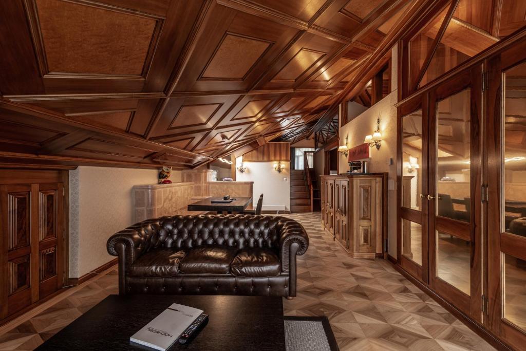 a leather couch in a living room with wooden ceilings at Boutique Hotel Albana Real - Restaurants & Spa in Zermatt