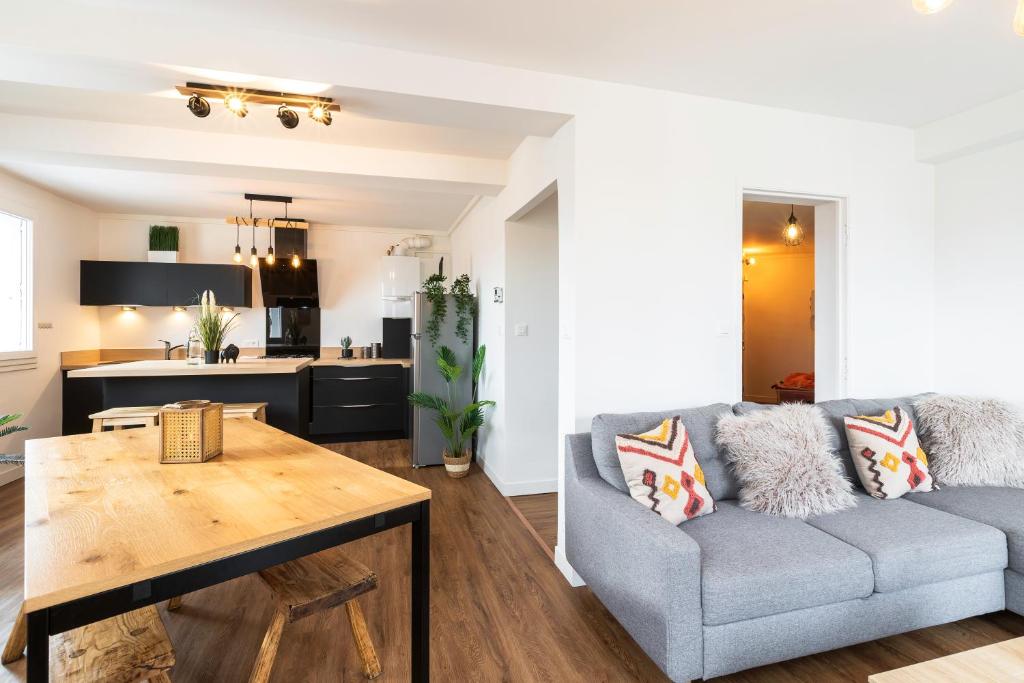 un salon avec un canapé et une table dans l'établissement DORMIR A CLERMONT-FERRAND - Safari, à Clermont-Ferrand