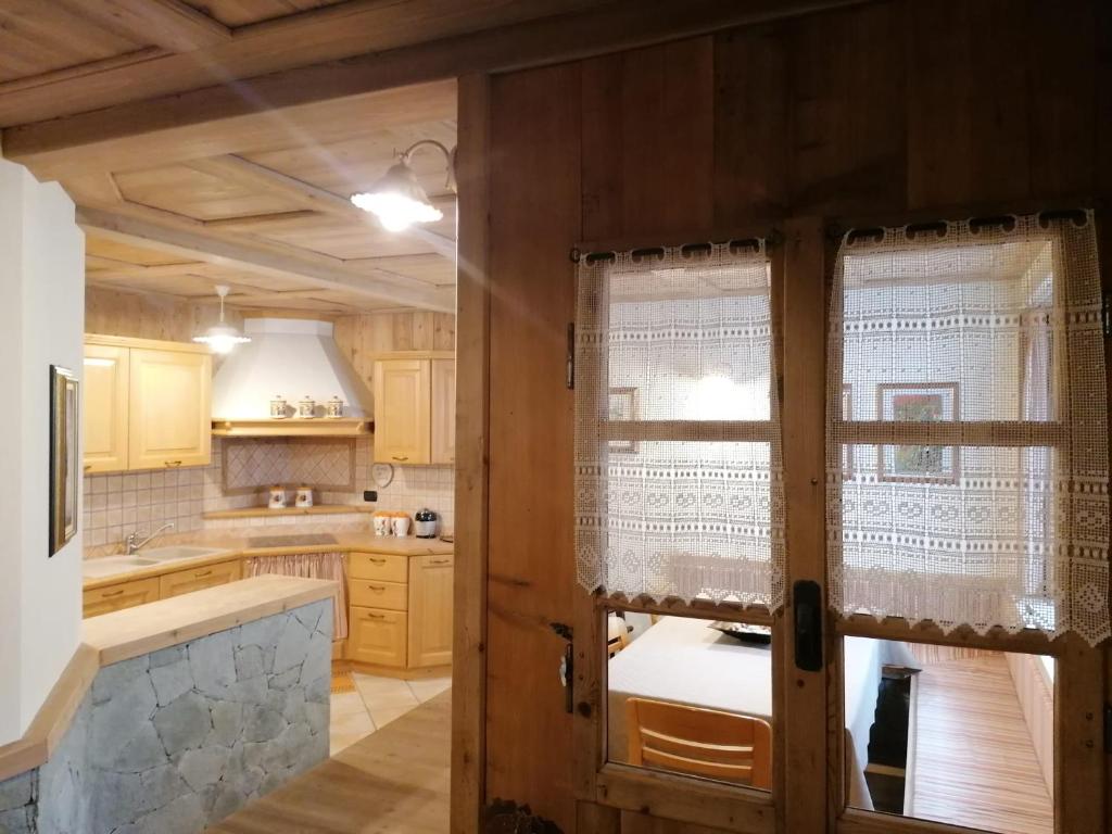 a kitchen with wooden cabinets and a large window at Taverna Larice in Valdidentro
