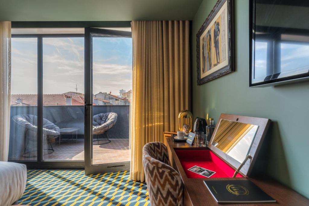 a living room with a view of a balcony at The Convo Porto Hotel & Suites in Porto