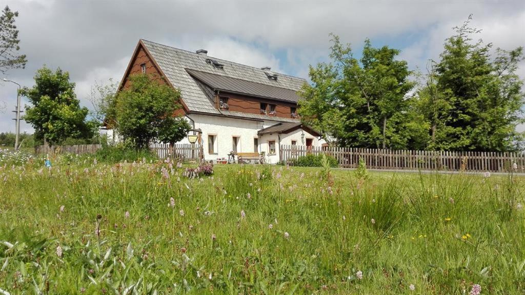 a house with a fence and a field of grass at Ferienwohnung Wagner in Kurort Altenberg