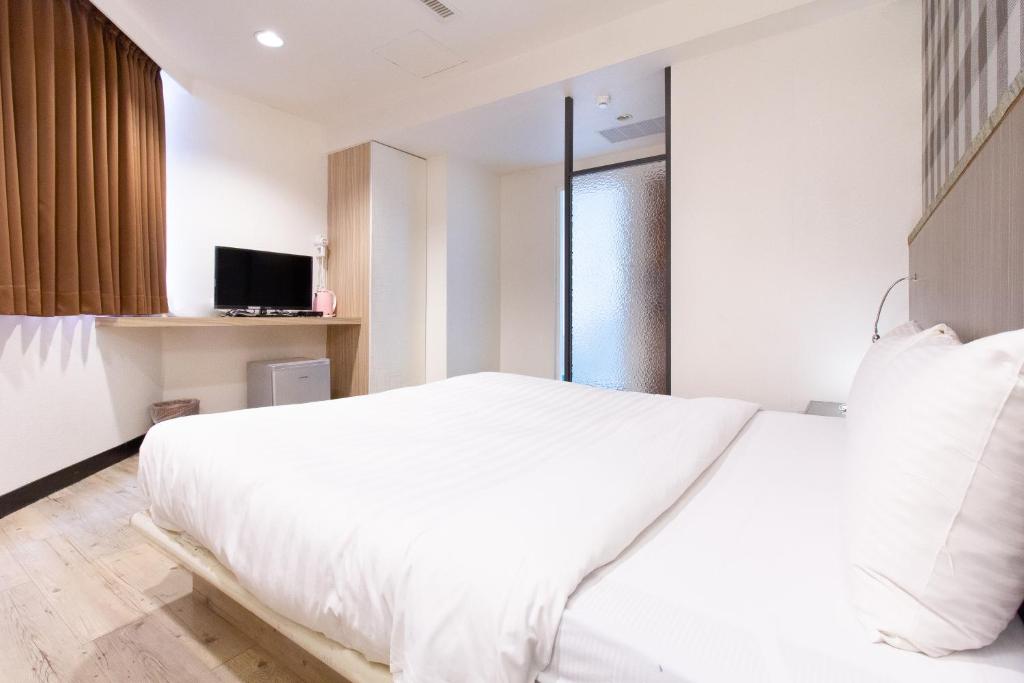 Postel nebo postele na pokoji v ubytování Hwa Nan Hotel