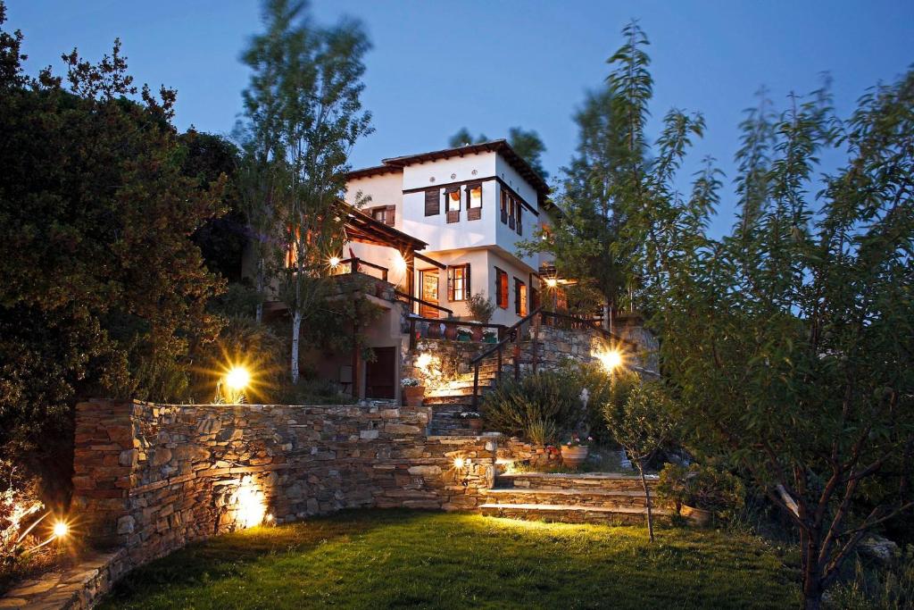 een huis met een stenen muur 's nachts bij Great Pelion Villa Villa Selini 4 bedrooms Private Pool Aghios Georgios in Agios Georgios Nilias