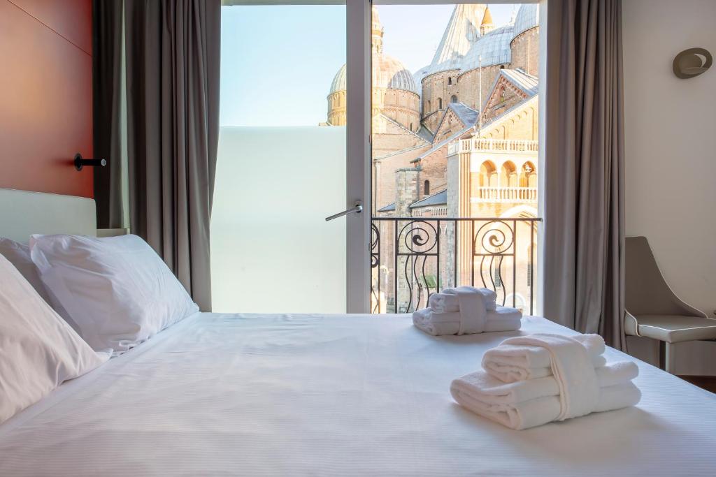 una camera d'albergo con un letto e asciugamani di Padova Suites C20 a Padova