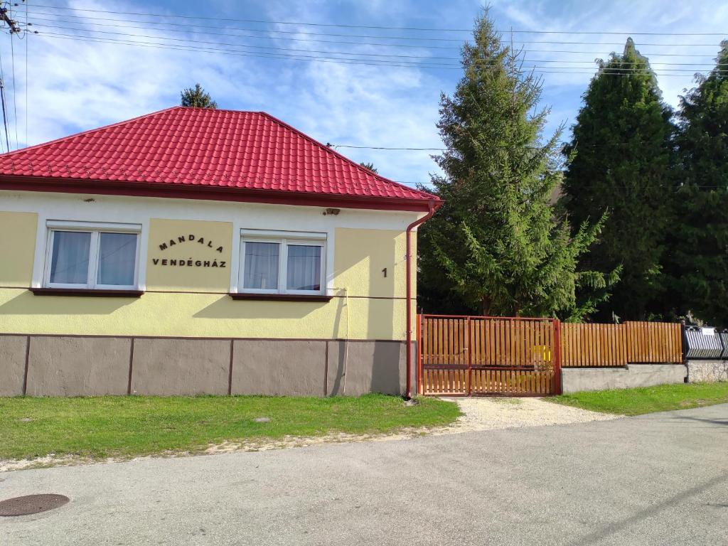 uma casa amarela e vermelha com um telhado vermelho em Bakonyi Mandala Ház em Bakonybél