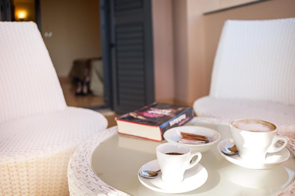 two cups of coffee on a table next to a bed at Rada Siri in Montepaone