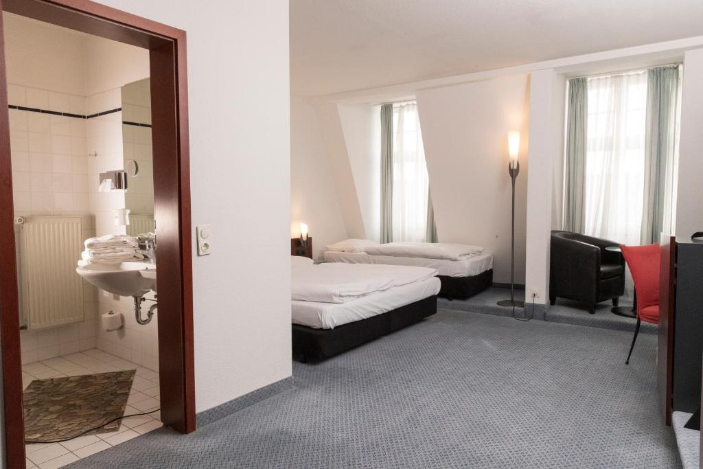 a hotel room with two beds and a bathroom at sweet dream hostel & pension - Self Check-In in Güstrow