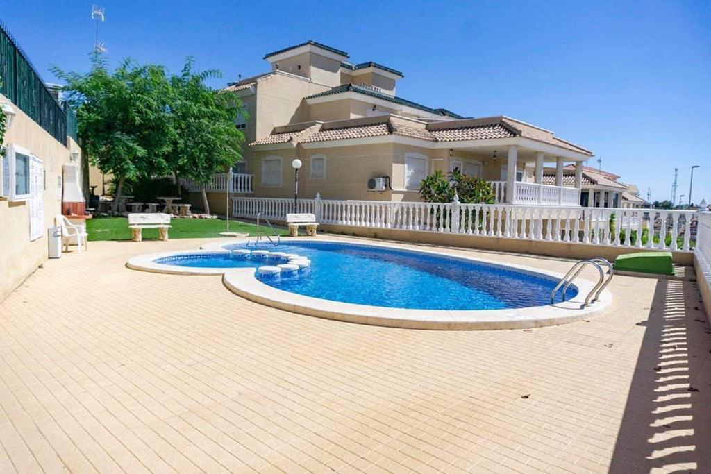 - une piscine en face d'une maison dans l'établissement Spacious 2 Bed Ground floor apartment with beautiful communal pool, à Villamartín