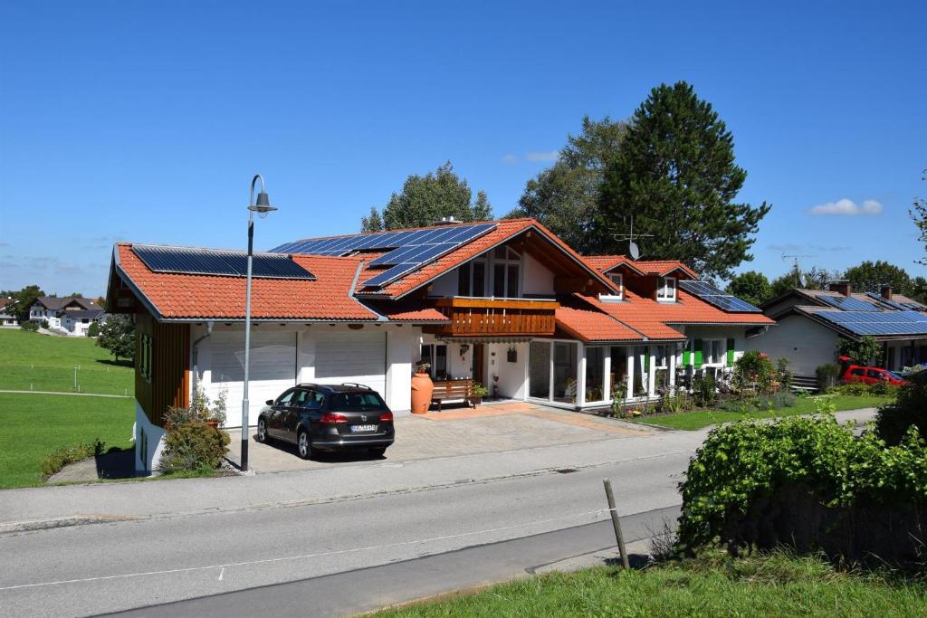 un coche aparcado frente a una casa con techos solares en Haus Gauß, en Seeg