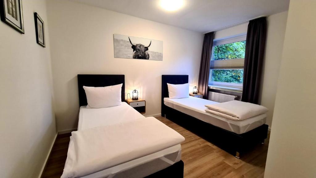 Habitación pequeña con 2 camas y ventana en Moes Diner Hotel, en Schloss Holte-Stukenbrock