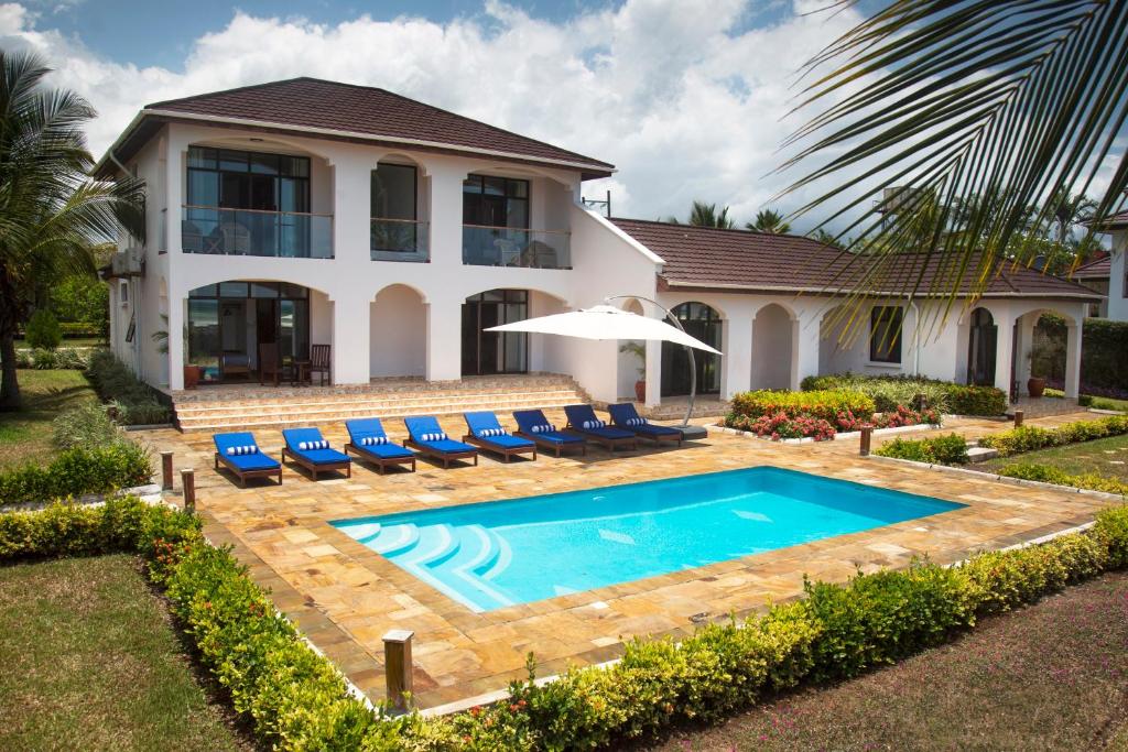 Kena Beach Villas في Marumbi: بيت فيه مسبح قدام بيت