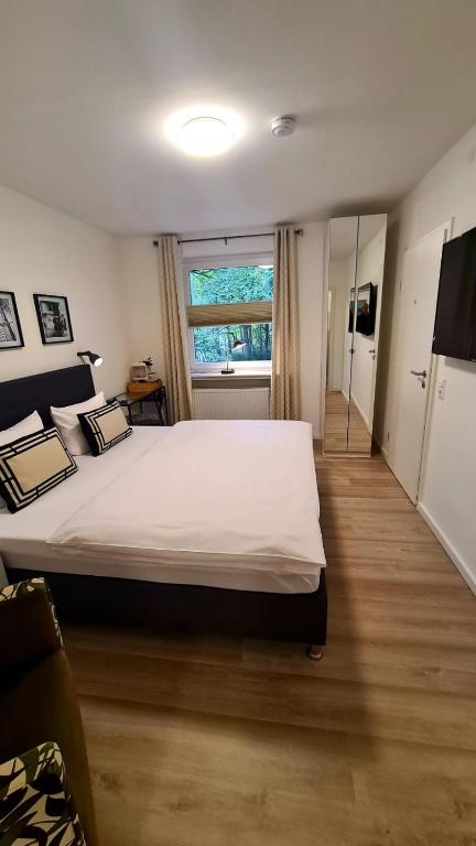 a bedroom with a large white bed and a window at Moes Hotel in Schloß Holte-Stukenbrock