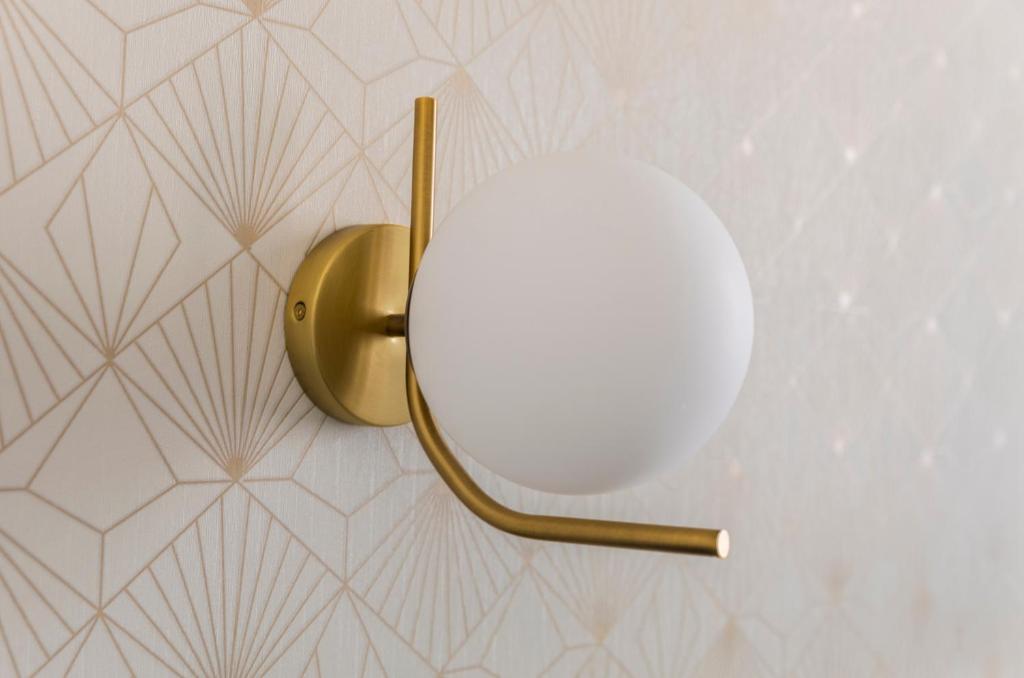 a mirror on a wall with a gold lamp at Hotel Coppede' in Rome