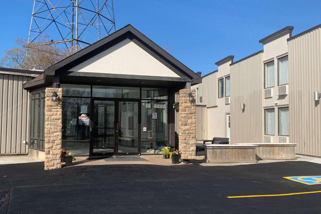 a building with a revolving door in a parking lot at Travelodge by Wyndham Miramichi New Brunswick in Miramichi