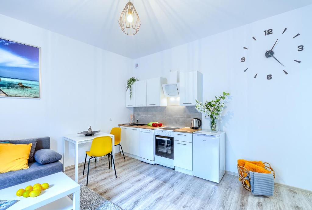 een woonkamer met een keuken met een klok aan de muur bij Lucky Place CENTRUM in Bielsko-Biala