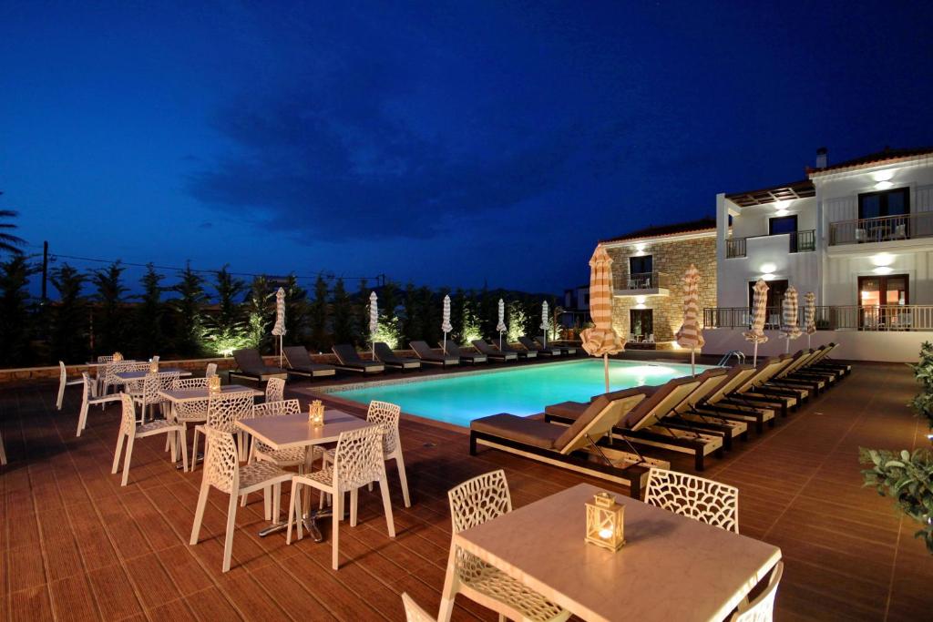 a patio with tables and chairs next to a pool at Elafonisos Resort in Elafonisos