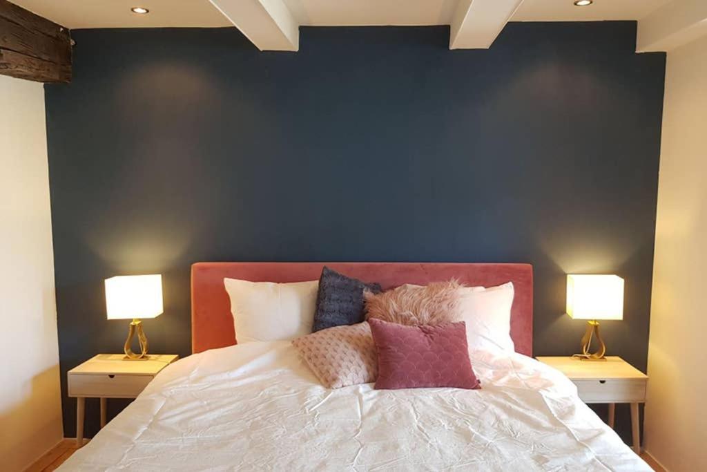 マーストリヒトにあるLuxurious Loft in Maastricht City Centerの青い壁のベッドルーム1室、ベッド1台(ランプ2つ付)