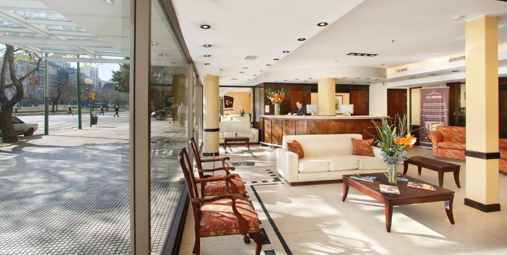 a lobby with a couch and a table and chairs at Embajador Hotel in Buenos Aires