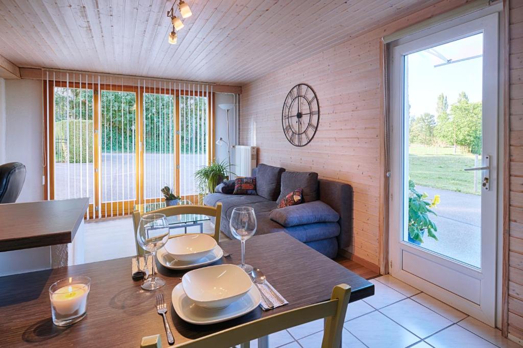 ein Esszimmer mit einem Tisch und einem Sofa in der Unterkunft Chez Marie-Claude in Vendlincourt