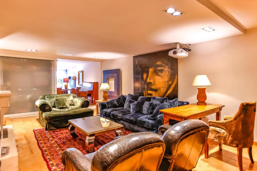 una sala de estar con muebles de cuero y una pintura en la pared en La Riviera Mediterránea, en Sitges