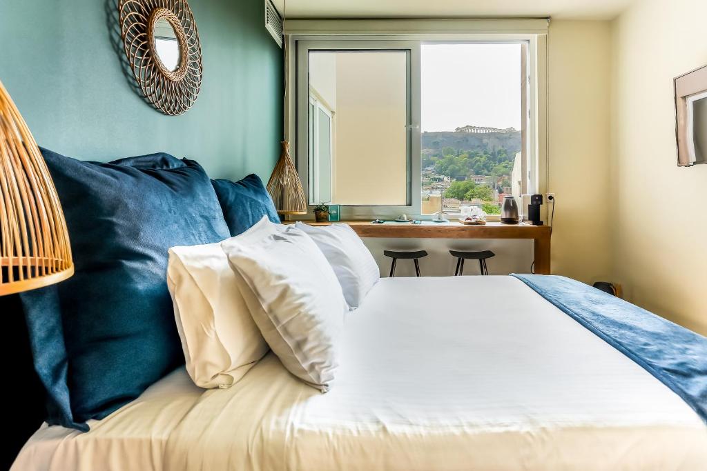 um quarto com uma cama com paredes azuis e uma janela em Ciel Living Athens em Atenas