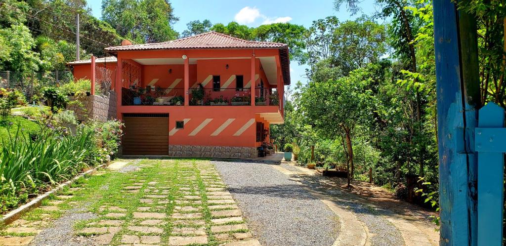 a red house with a driveway leading to it at Casa do Lago in Cunha