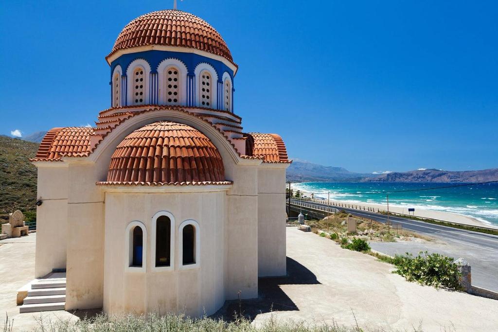 mały budynek z czerwonym dachem obok plaży w obiekcie Eagles Villas Halkidiki Ocean One Bedroom Pool Villa With Private Garden w mieście Uranupoli