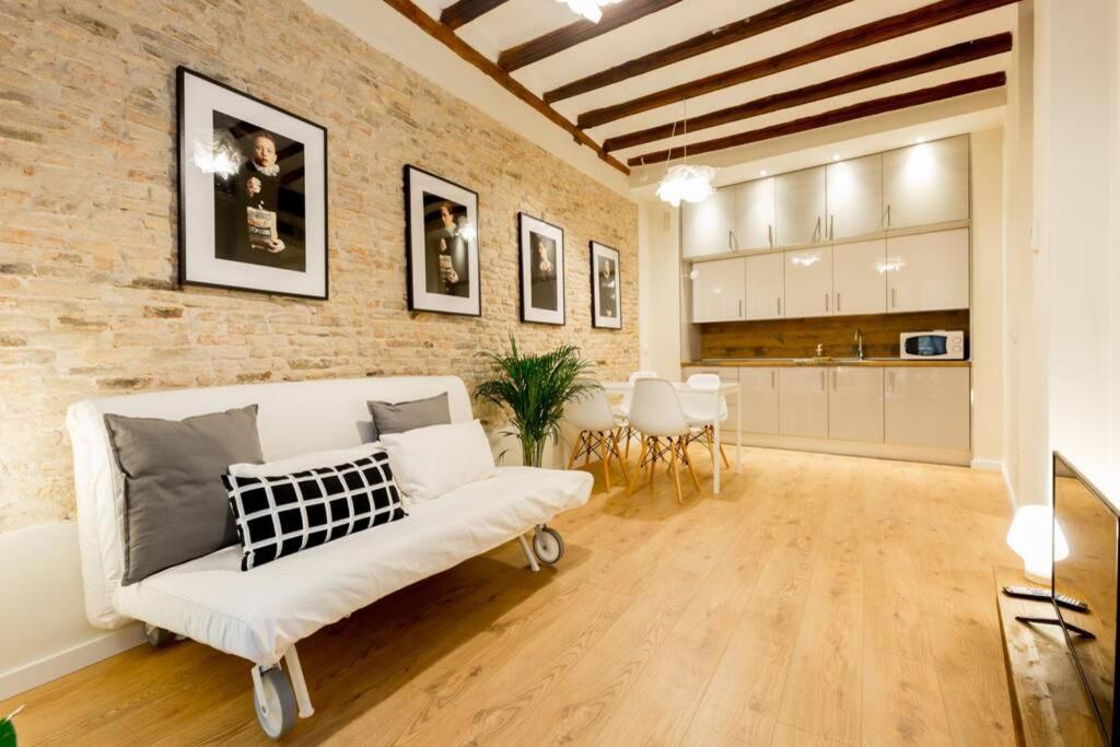sala de estar con sofá blanco y pared de ladrillo en CA1 - Apartamento céntrico de 1 dormitorio con opción de garaje, en Zaragoza